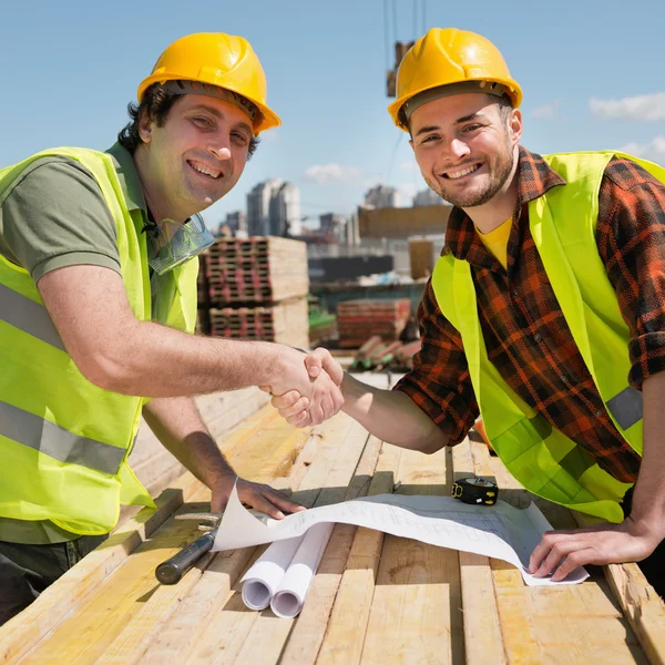 Trabalhadores da construção apertando as mãos — Fotografia de Stock