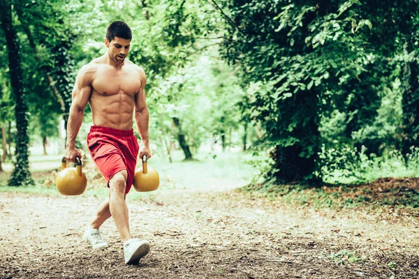 Atleta crossfit che cammina con le campane del bollitore — Foto Stock