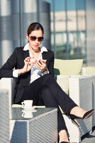 Affärskvinna på kaffepaus med telefon — Stockfoto