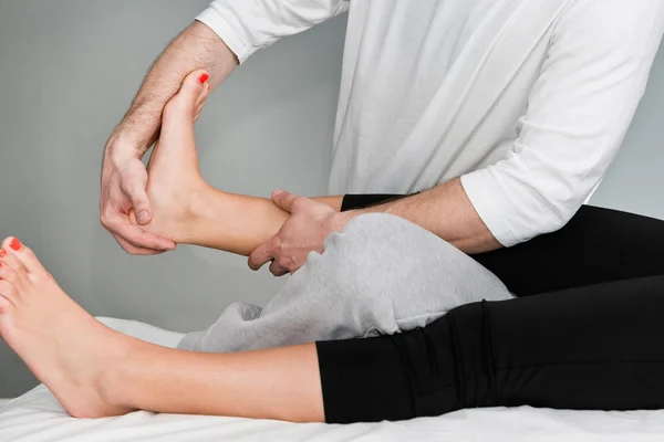 Chiropractic examining patient foot