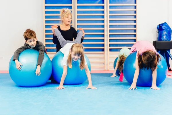 Kindergruppe trainiert mit Fitnessbällen — Stockfoto