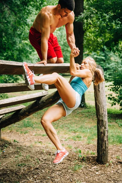 Muscular couple exercising on fitness trail — Stock Photo, Image