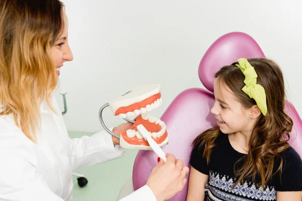 Дівчина у стоматолога дізнається про гігієну — стокове фото