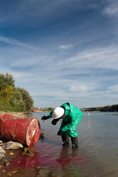 Environmentalist in protective suit taking sample 