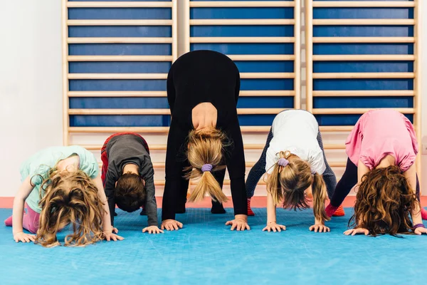 Lichamelijke opvoeding - leraar met kinderen uit te oefenen — Stockfoto