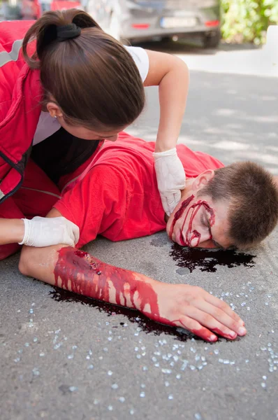 Paramedic with car accident victim on street — Stock Photo, Image