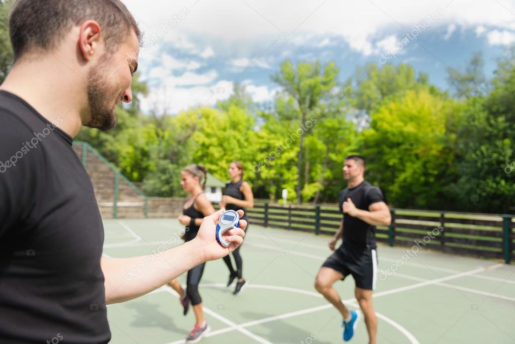 Trainer with stopwatch during cardio workout — Stock Photo © microgen