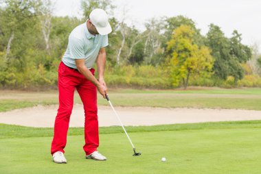 golfçü koyarak topu 