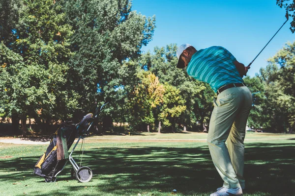 Golfer swings on putting green — Stock Photo, Image