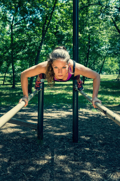 athlete doing push-ups on bars