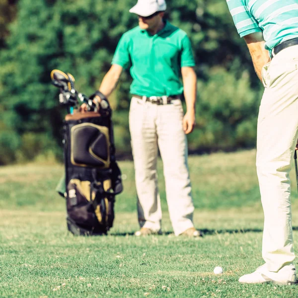 Golfaren med caddy att välja golf club — Stockfoto