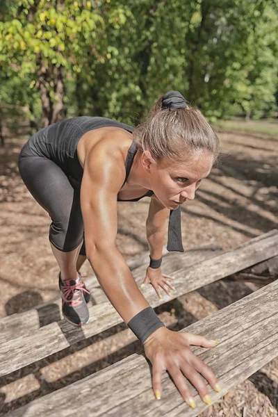 Athlete crossing wooden barriers — Stock Photo, Image