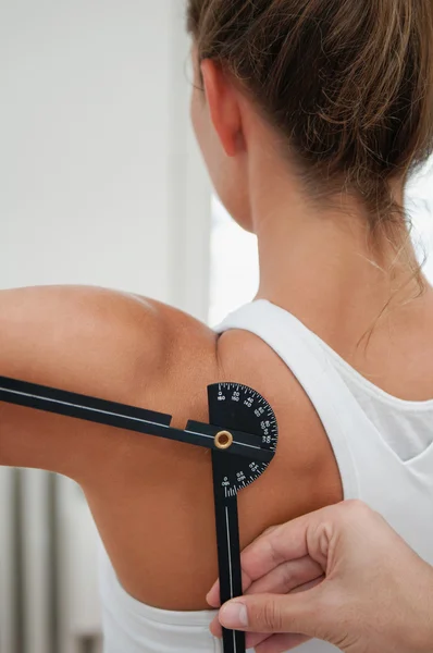 Fisioterapista che misura la flessione della spalla — Foto Stock