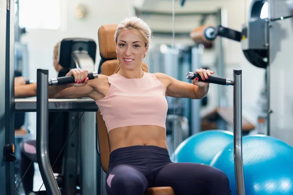 Spor salonunda egzersiz ve kameraya bakarak kadın — Stok fotoğraf