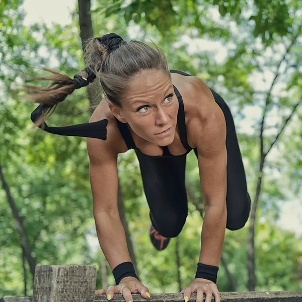 Athletin springt über hölzerne Hürde — Stockfoto