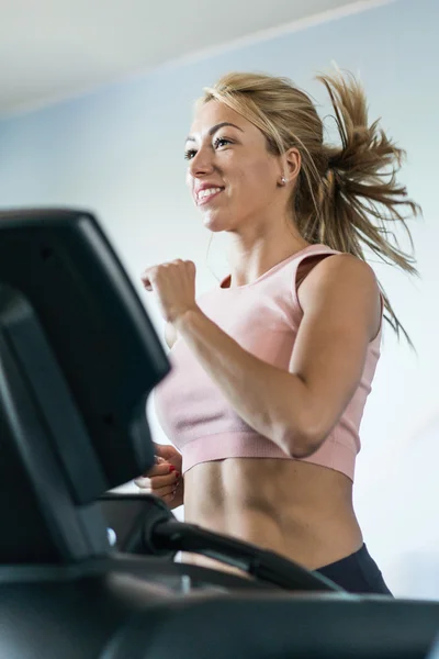 Attractive woman jogging on treadmill — Stock Photo, Image