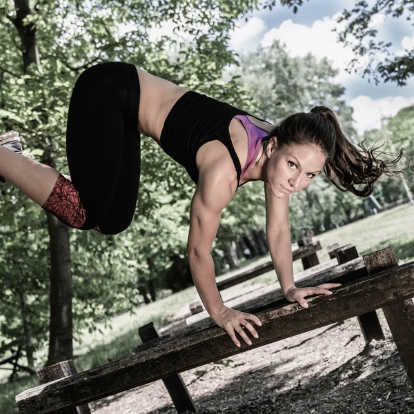 Woman crossing  barriers on fitness trail — Stock Photo, Image