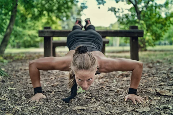 Vrouwelijke atleet doet push ups — Stockfoto
