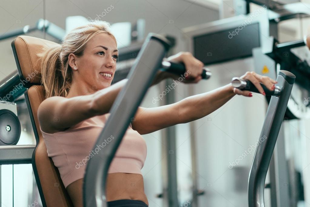Woman exercising Chest press workout Stock Photo by ©microgen