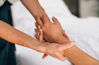 Ayurveda terapisti ruhani yağla kol masajı yapıyor.
