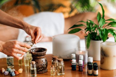 Ayurveda aromaterapi masajı, kadın elinin gerekli yağ dağıtıcısına aromatik yağ dökmesi.