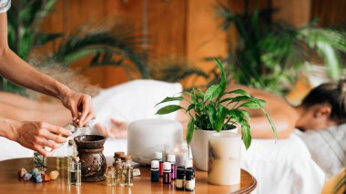 Ayurveda aromaterapi masajı, kadın elinin gerekli yağ dağıtıcısına aromatik yağ dökmesi.