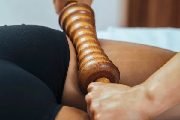 Madero therapy back thigh muscle massage with wooden rolling pin or battledore