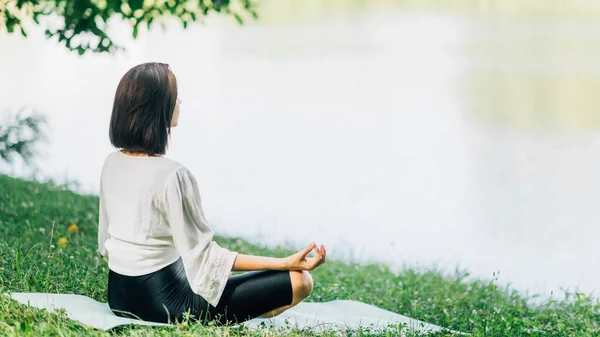 Mujer Joven Sentada Posición Loto Practicando Meditación Cerca Del Agua — Foto de Stock