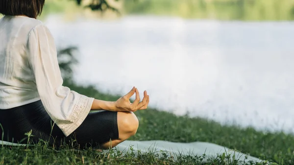 Jovem Mulher Sentada Posição Lótus Praticando Meditação Perto Água Natureza — Fotografia de Stock