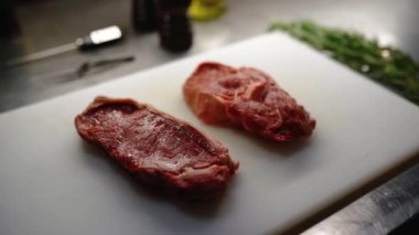 Evde biftek pişirmek, kesme tahtasında biftek, ızgara çizgili sulu biftek, şefin ete biberiye koyması.