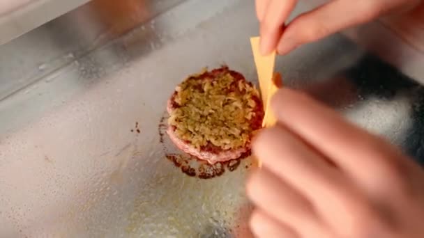Kocken förbereder en hamburgare. Nötkött, fläsk, gurka, sås och lök. — Stockvideo