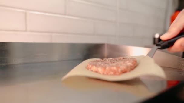 Le chef prépare un hamburger. Boeuf, porc, concombre, sauce et oignon. — Video