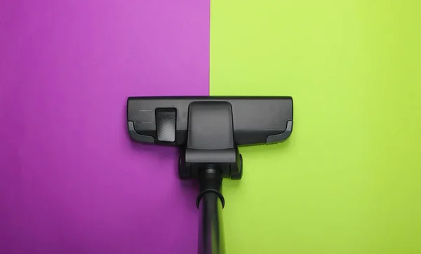 Vacuum cleaner brush on green purple background. Top view. Cleaning concept.