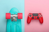 Červený Gamepad s křižníkem palubě na růžové modré pastelové pozadí. Dětský koncept, letní zábava, zábava. Horní pohled. Plocha