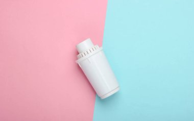 Pembe mavi pastel arka planda su arıtıcısının filtresi. Üst görünüm