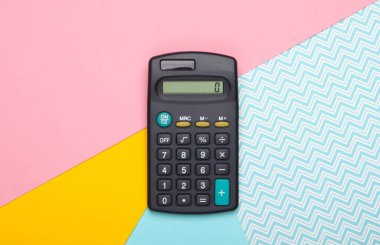 Pastel renkli arka planda bir hesap makinesi. Üst görünüm