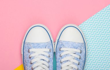 Renkli arka planda eski moda eski moda spor ayakkabılar. Pastel renk eğilimi. Üst görünüm