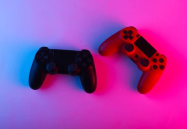İki adet neon mavi-pembe ışıklı Gamepad. Oyun konsepti.