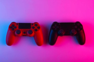 İki adet neon mavi-pembe ışıklı Gamepad. Oyun konsepti.