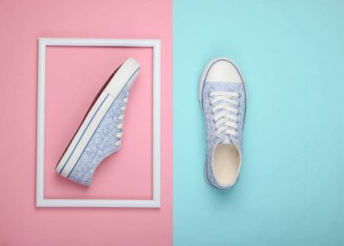 Pembe-mavi pastel arka planda beyaz çerçeveli Retro ayakkabılar. Minimalizm. Üst görünüm