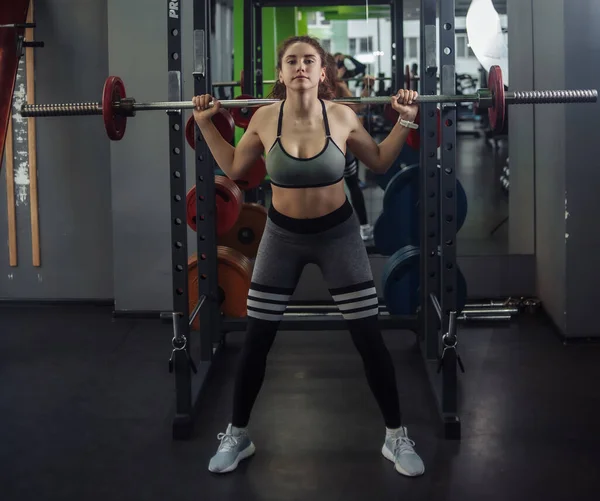 Jovem Mulher Sportswear Agachamentos Com Uma Barra Seus Ombros Ginásio — Fotografia de Stock