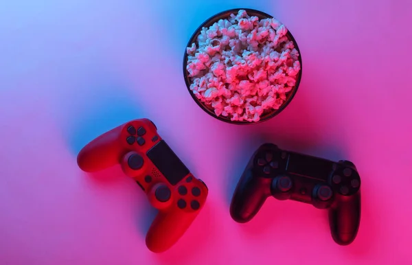 Två Gamepads Och Skål Popcorn Neonrosa Blått Ljus Spel Fritid — Stockfoto