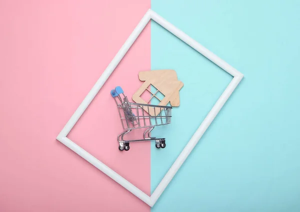 Einkaufswagen Mit Mini Haus Weißem Rahmen Auf Rosa Blauem Pastellhintergrund — Stockfoto