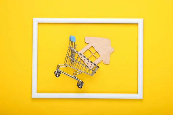 Winkelwagentje Met Mini Huis Een Wit Frame Gele Achtergrond Huisaankoop — Stockfoto