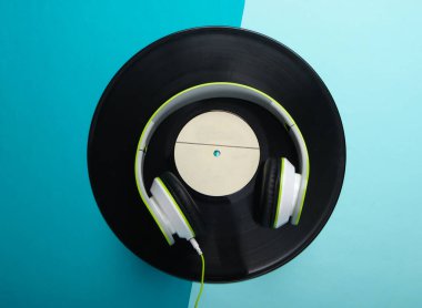 Havalı telli kulaklıklar ve mavi arka planda vinil plaklar. Müzik aşığı. Retro 80 'ler. Üst görünüm.