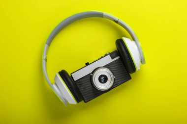 Yeşil arka planda retro kameralı stereo kulaklıklar. Müzik aşığı. Seyahat konsepti. Retro 80 'ler. Üst görünüm.
