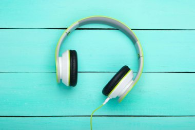 Kablolu müzik kulaklıkları mavi ahşap tahtalarda. Müzik aşığı. Aletler. Üst görünüm.