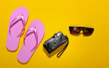 Yaz tatili konsepti, seyahat. Sarı arka planda plaj aksesuarları falan. Stüdyo çekimi. Düz yatıyordu