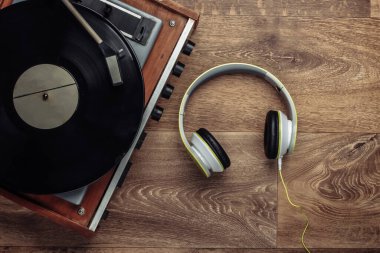 Ahşap zeminde stereo kulaklıklı Retro Vinil Plak çalar. Üst görünüm
