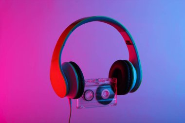 Stereo kulaklıklar ve ses kaseti. Neon parlak pembe-mavi ışık. Kıvılcım. Siberpunk 80 'ler